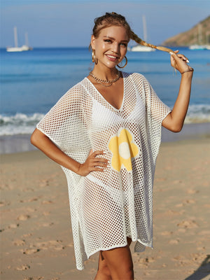White crochet beach cover-up with yellow daisy appliqué and V-neck