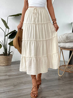 Cream tiered midi skirt with drawstring waist and textured fabric.
