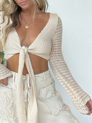 Beige crochet tie-front cropped cardigan with cutout details and long sleeves.
