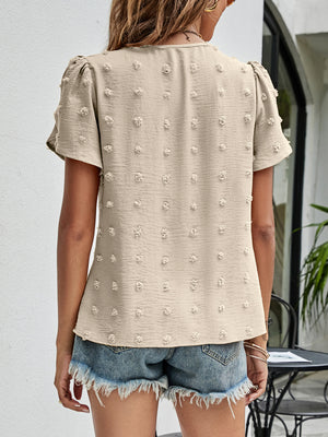 Beige textured puff sleeve dot blouse with short sleeves and a v-neck.