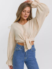 Ochre textured puff sleeve blouse with ruffled cuffs and tie front, button-down detail.