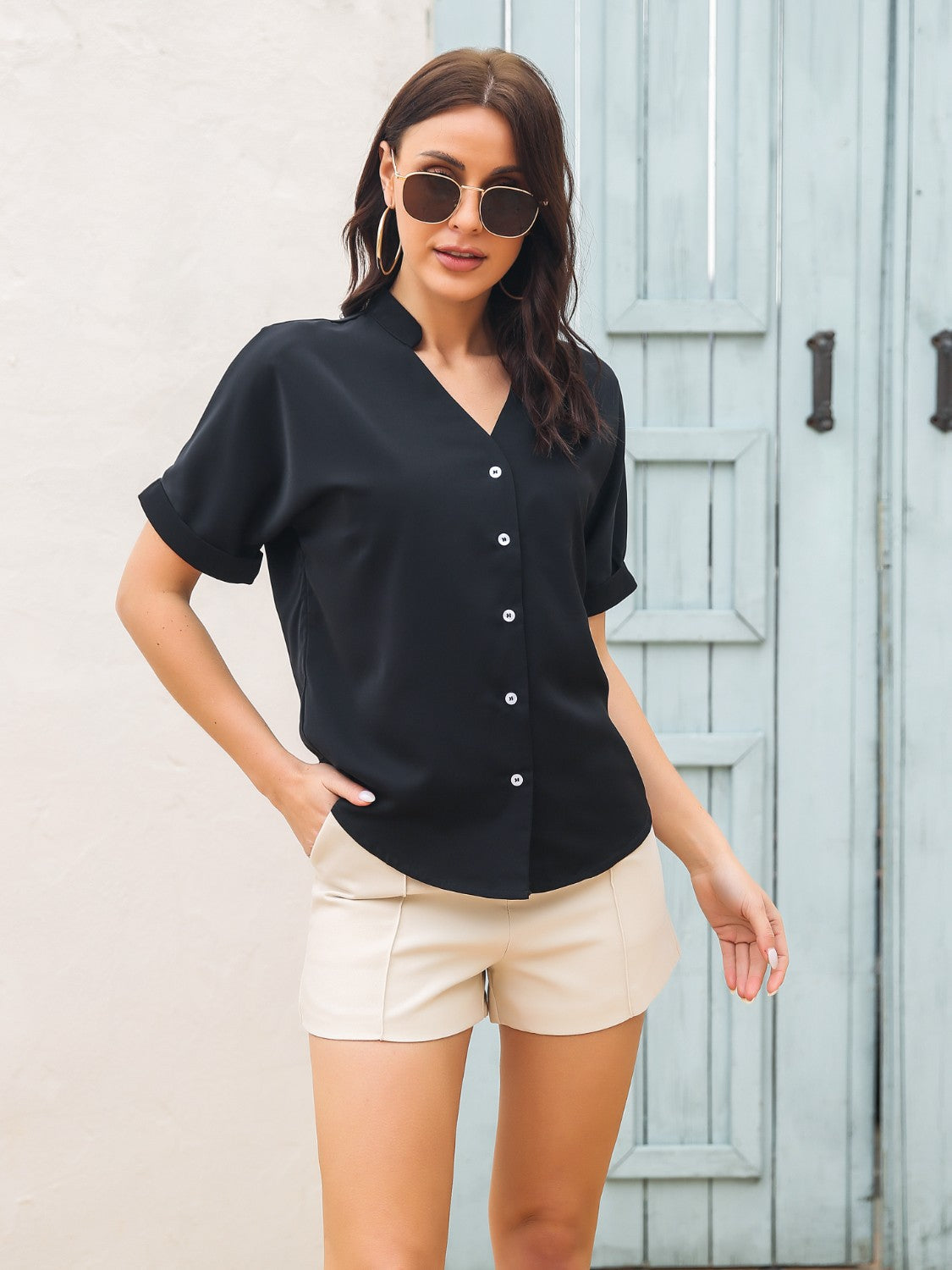 Black short sleeve buttoned blouse with a notch neckline.