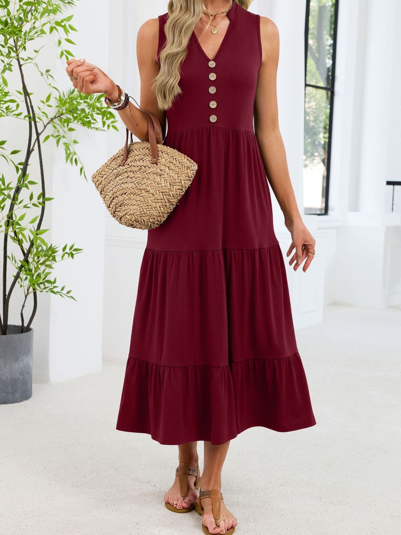 Burgundy tiered midi dress with notched V-neck and decorative buttons.