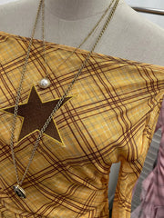 Yellow plaid asymmetrical ruffle hem t-shirt with a star cutout detail.