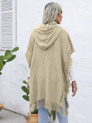 Khaki knit poncho with hood, fringe, and diamond pattern detail.