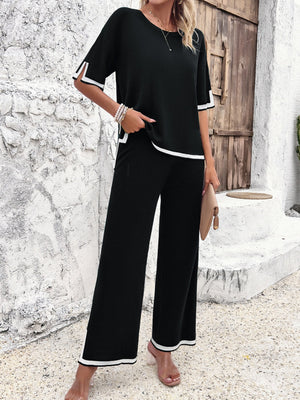 Black knit co-ord set with contrast white trim on short sleeves and wide-leg pants.