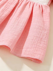 Pink baby dress with smocked bodice and textured cotton skirt