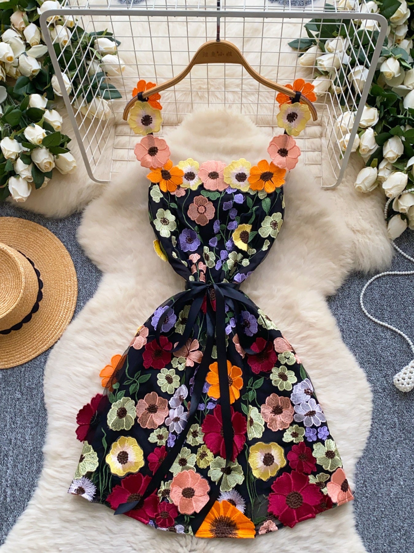 Black mini dress with embroidered floral detail and bow accent