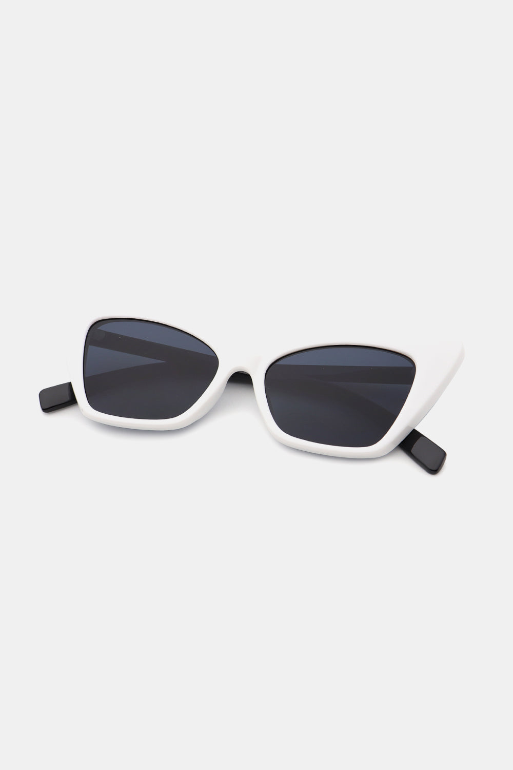 White acetate cat-eye sunglasses with sharp angular frames and black lenses.