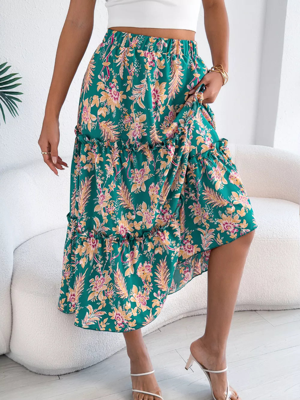 Green floral midi skirt with ruffle hem and tiered design.