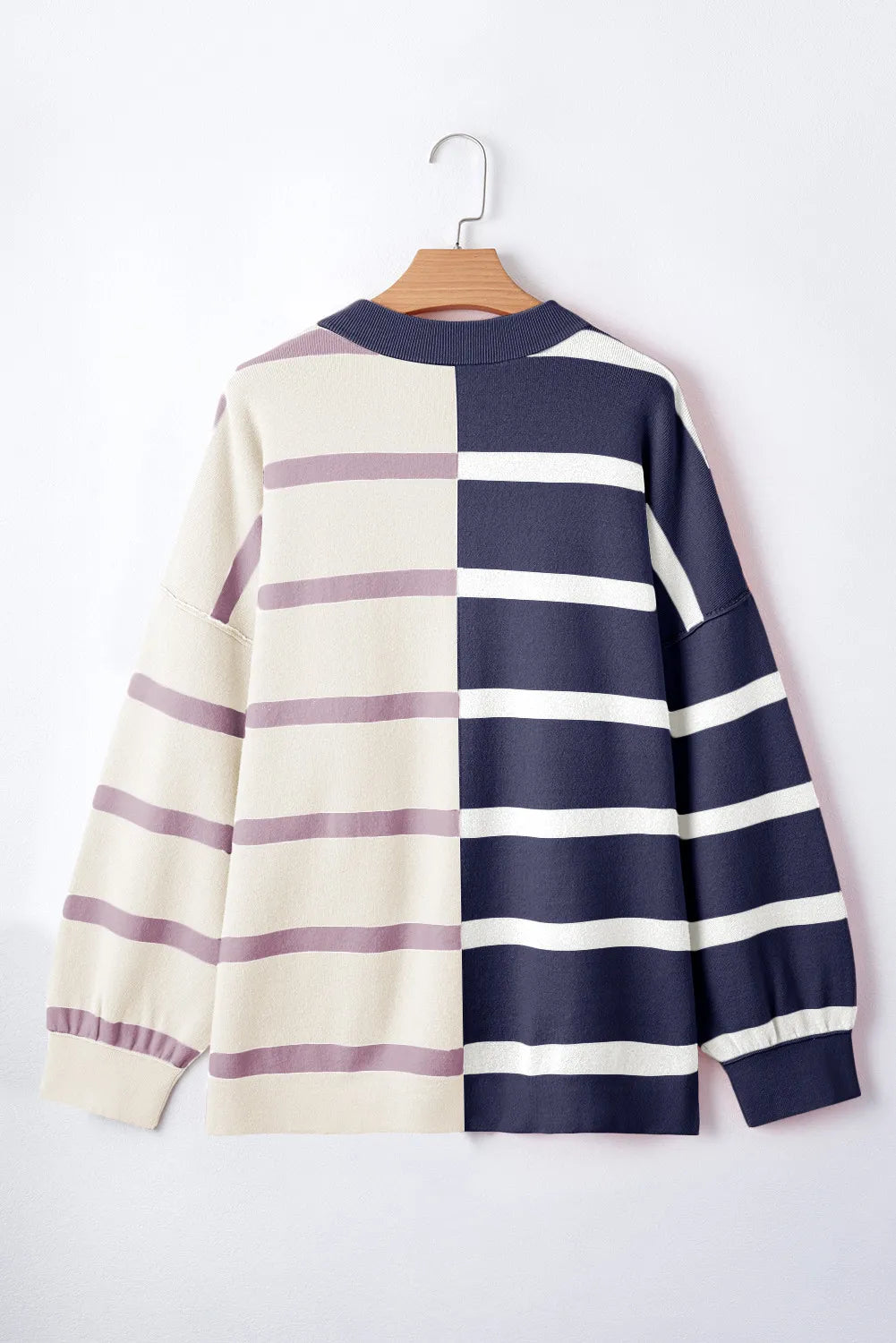 Colorblock stripe knit pullover sweater with navy and cream panels and purple stripes.