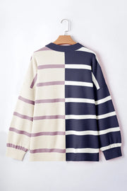 Colorblock stripe knit pullover sweater with navy and cream panels and purple stripes.