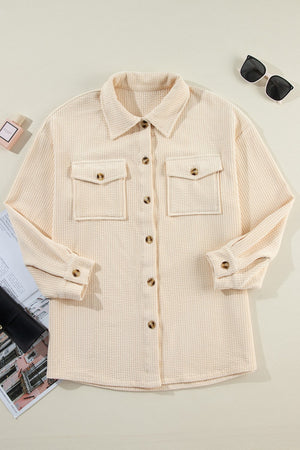 Beige textured corduroy oversized utility jacket with button front and chest pockets.