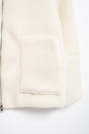 White sherpa jacket with zip front and patch pocket detail.
