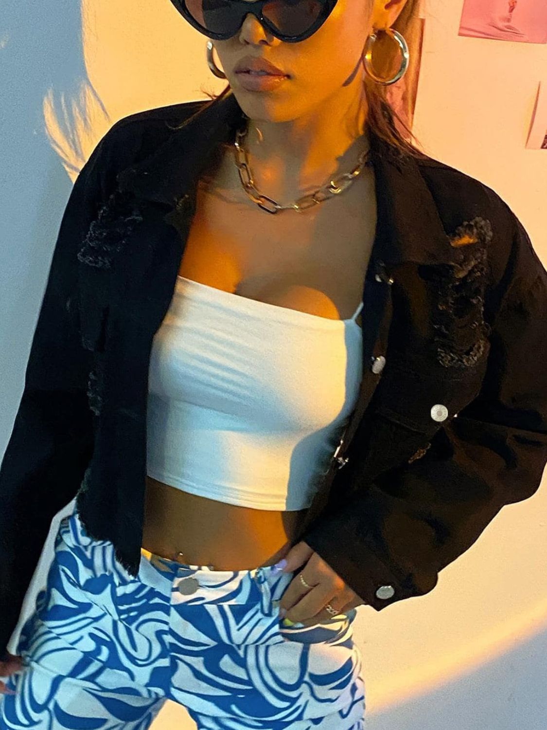 Black cropped distressed denim trucker jacket with collar and button details.