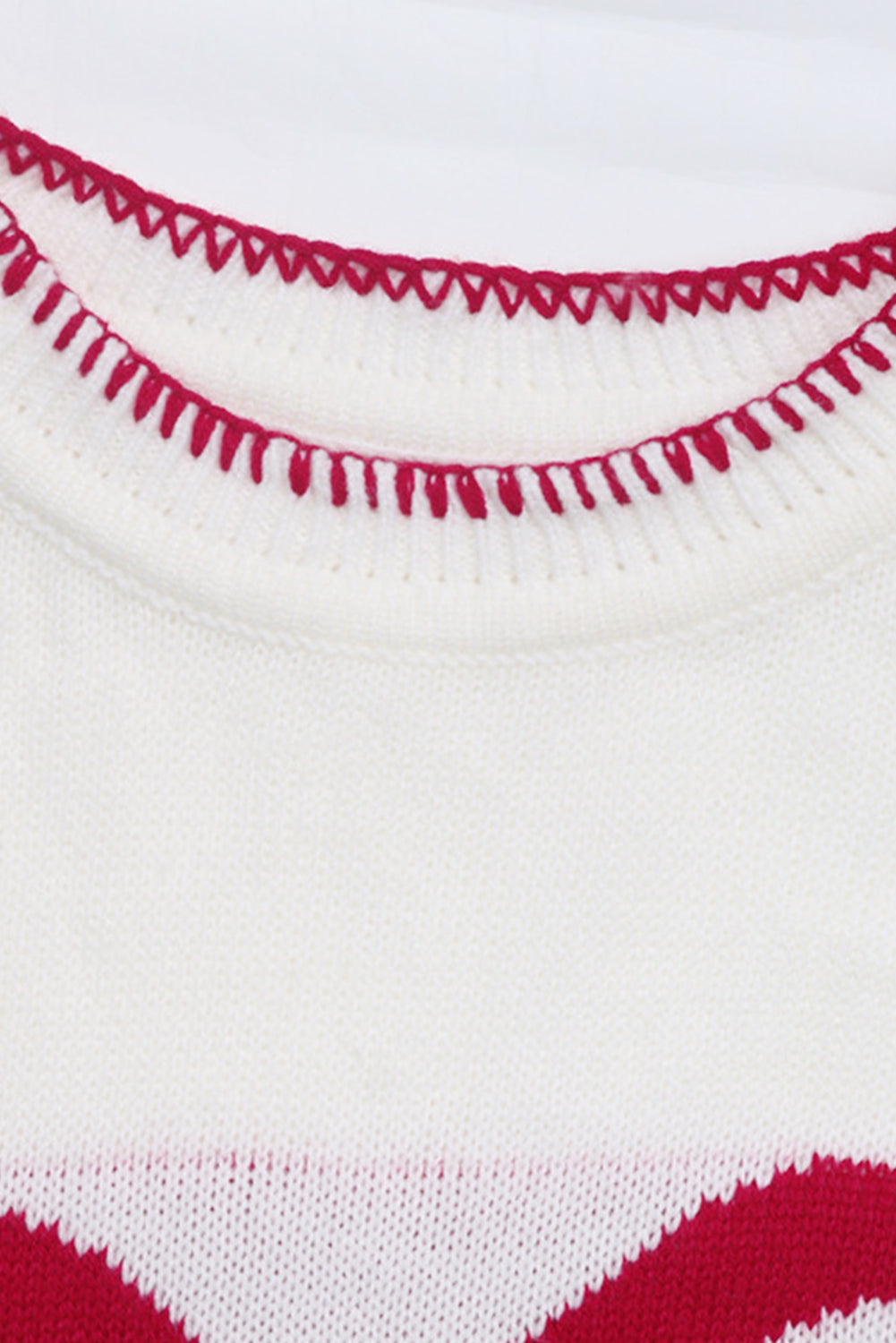White knit sweater with red zigzag trim detail and festive bow graphic.