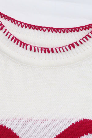 White knit sweater with red zigzag trim detail and festive bow graphic.