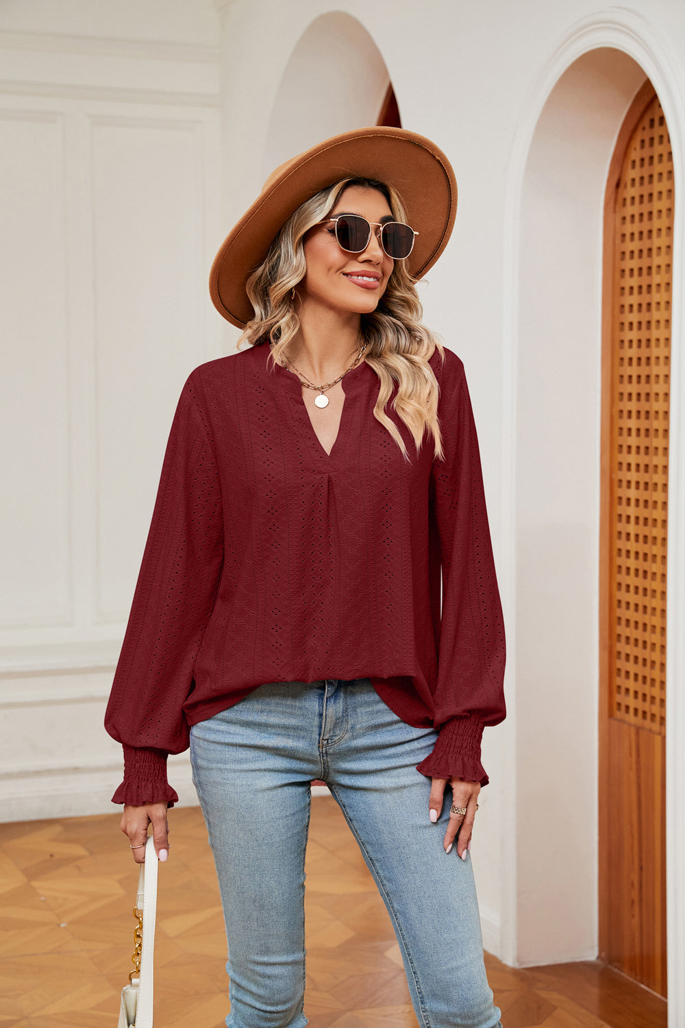 Wine eyelet detail poet sleeve blouse with V-neck and ruffled cuffs.