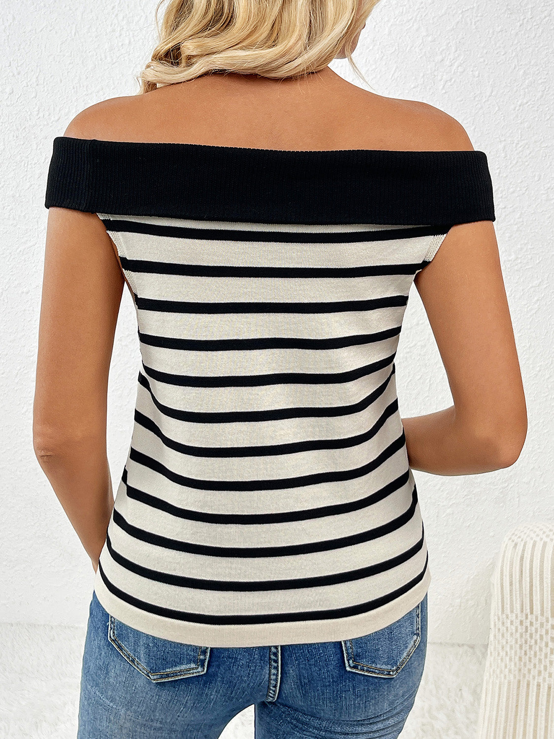 Off-shoulder knit top with black and white stripes and a black neckline.