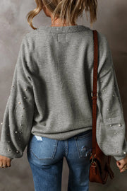 Gray knit sweater with pearl-embellished sleeves and crew neck.