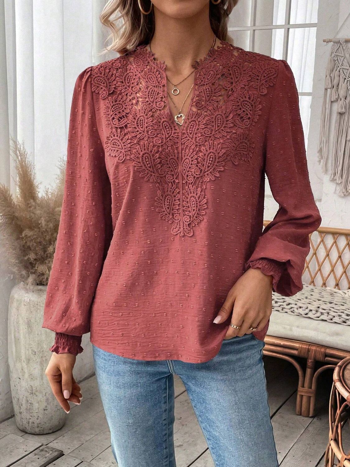 Embroidered yoke blouse in rust with puff sleeves and textured fabric.