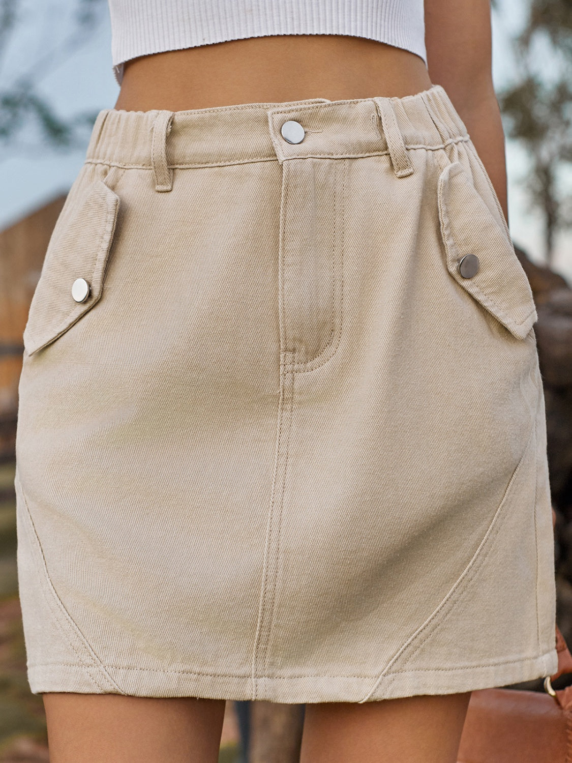 Tan utility pocket mini skirt with elastic waist and button details.