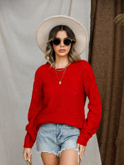 Red diamond-cut raglan knit sweater with crew neck and long sleeves.