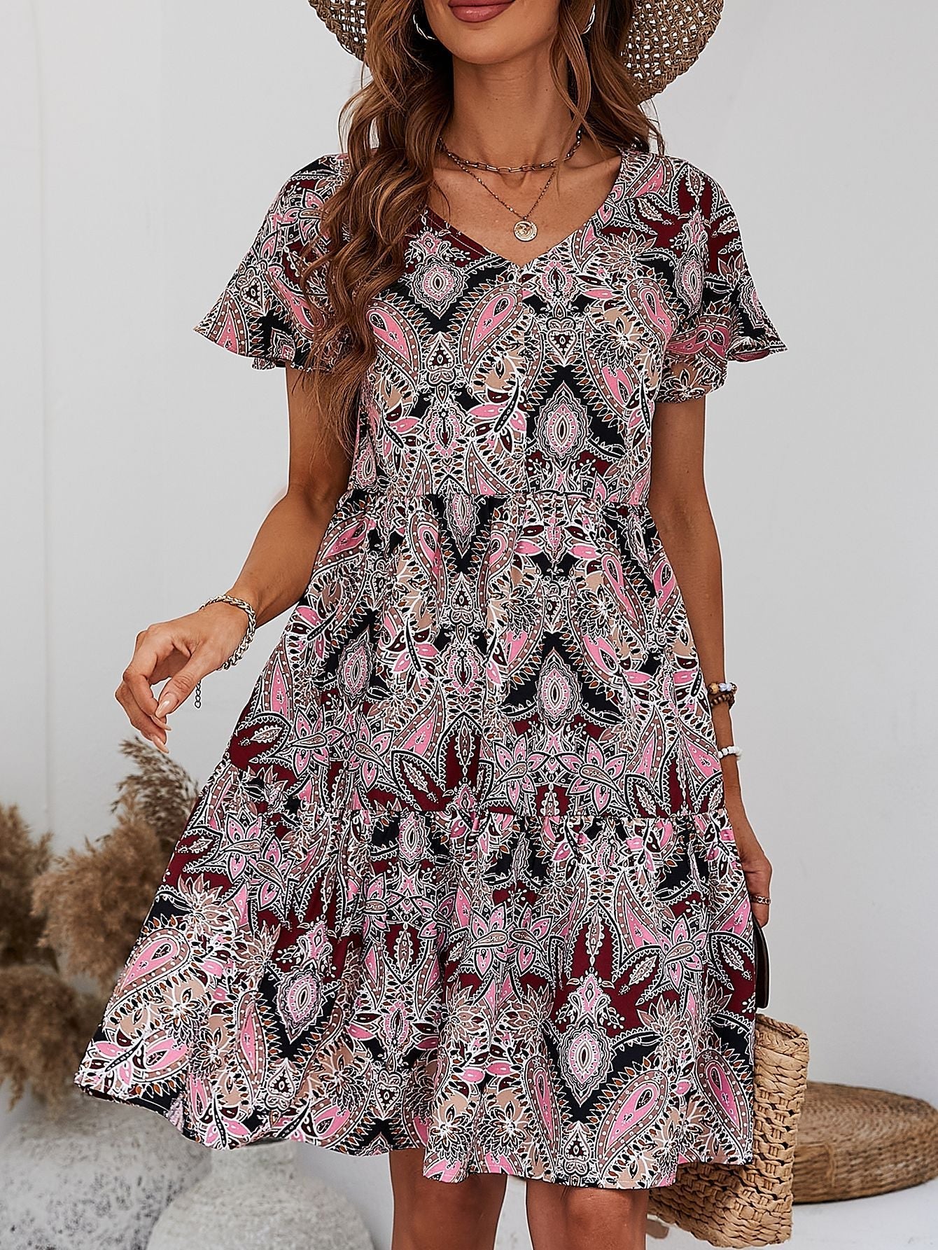 Paisley print mini dress with flutter sleeves and tiered skirt in cream, pink, and black.