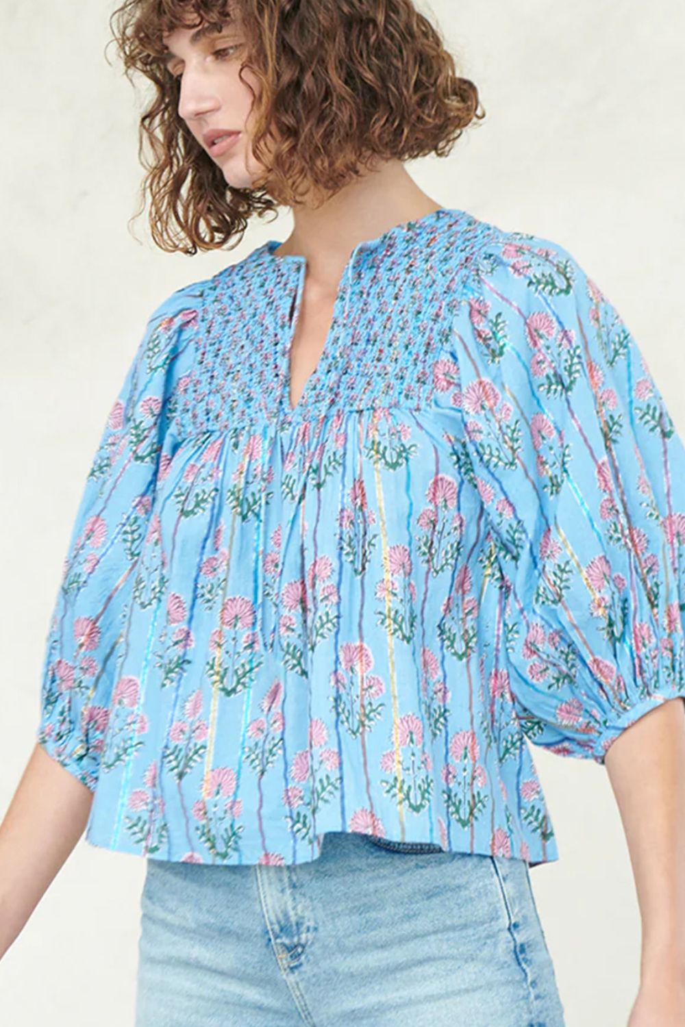 Sky blue floral print smocked yoke blouse with puff sleeves and metallic stripes.