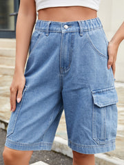Medium wash denim cargo bermuda shorts with elastic waist and utility pockets.