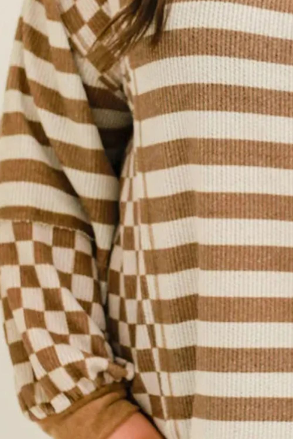 Brown and white striped waffle knit top with checkerboard sleeves.