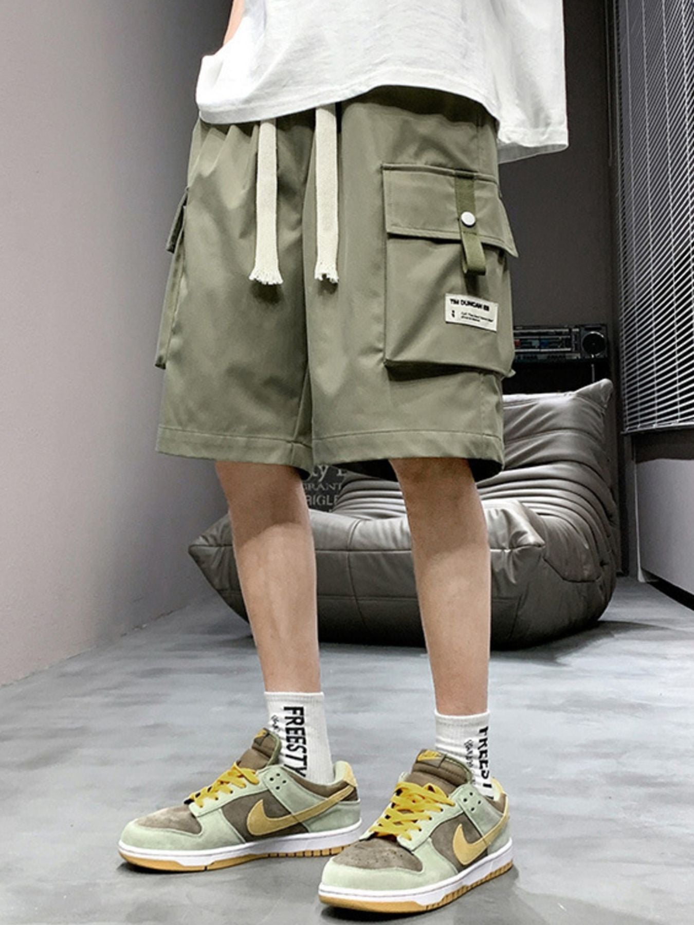 Men's green lightweight cargo shorts with drawstring and multiple pockets.