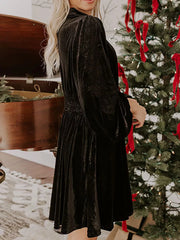 Black velvet mock neck dress with balloon sleeves and smocked waist.