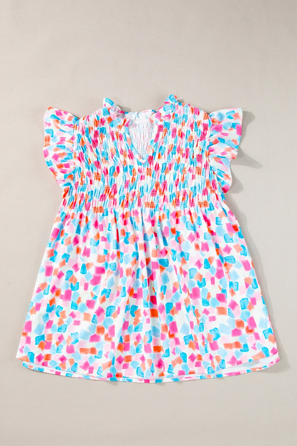 Smocked bodice blouse with brushstroke print, V-neck, and flutter sleeves in a multi-color pastel palette.