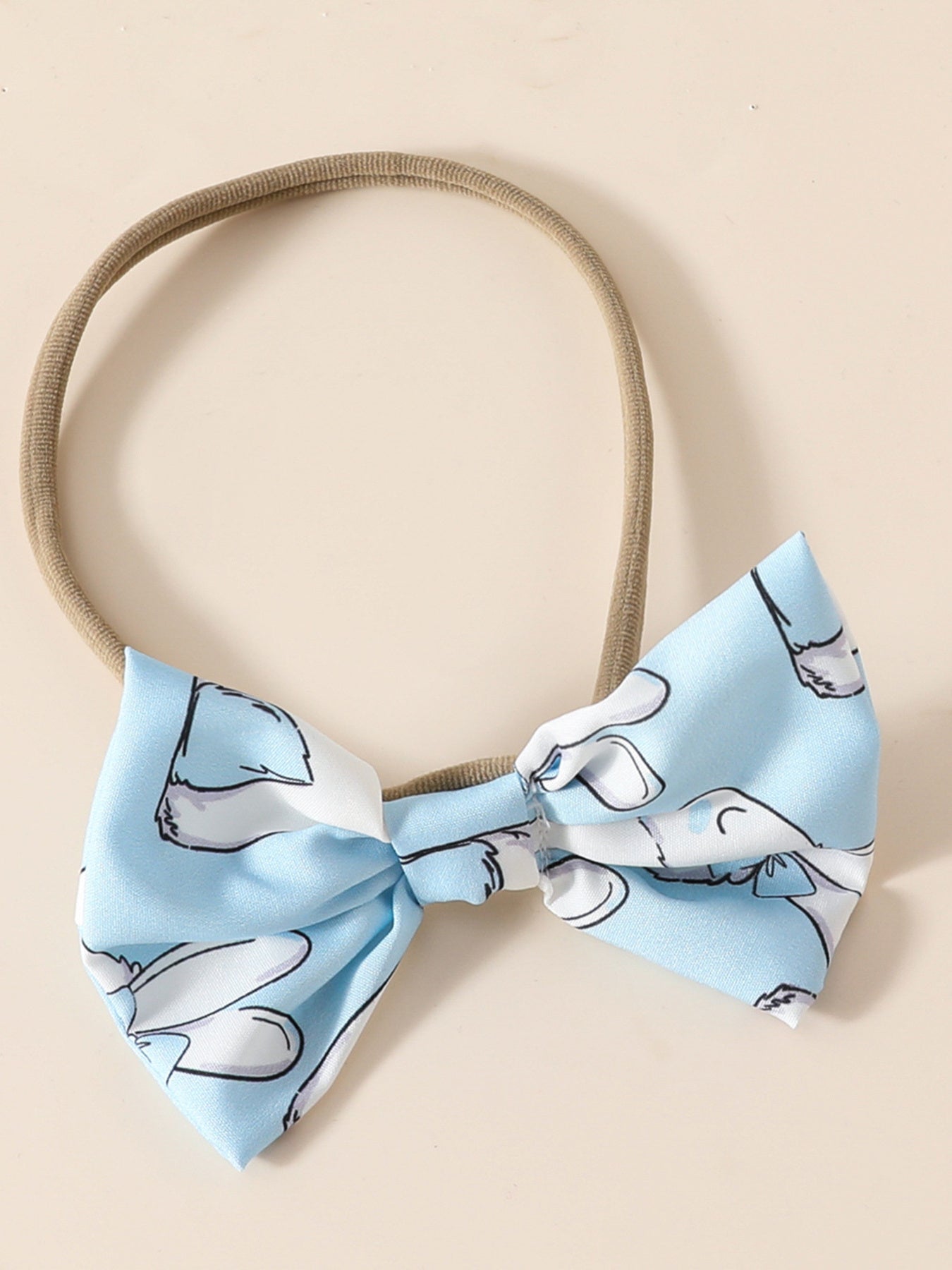 Sky blue baby headband with a bow featuring a whimsical bunny print.