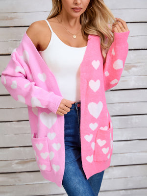 Pink acrylic blend cardigan with white heart pattern, open front, long sleeves, and pockets.