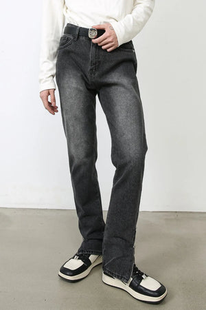 Dark washed denim trousers with split hem detail and zipper closure.