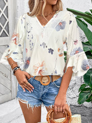 White floral bell sleeve blouse with lace trim neckline.