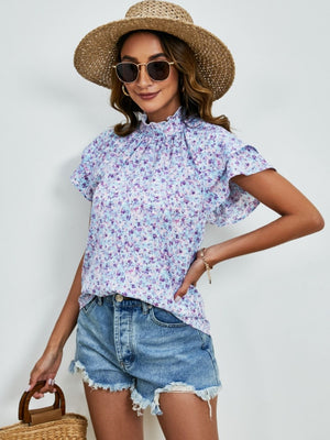 Light blue floral blouse with ruffled neckline and flutter sleeves