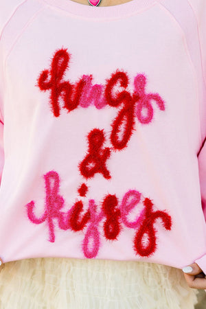 Blush pink sweatshirt with fuzzy red and pink "hugs & kisses" embroidery