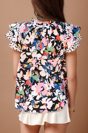Dalmatian trim floral print blouse with ruffled sleeves and a high neckline.
