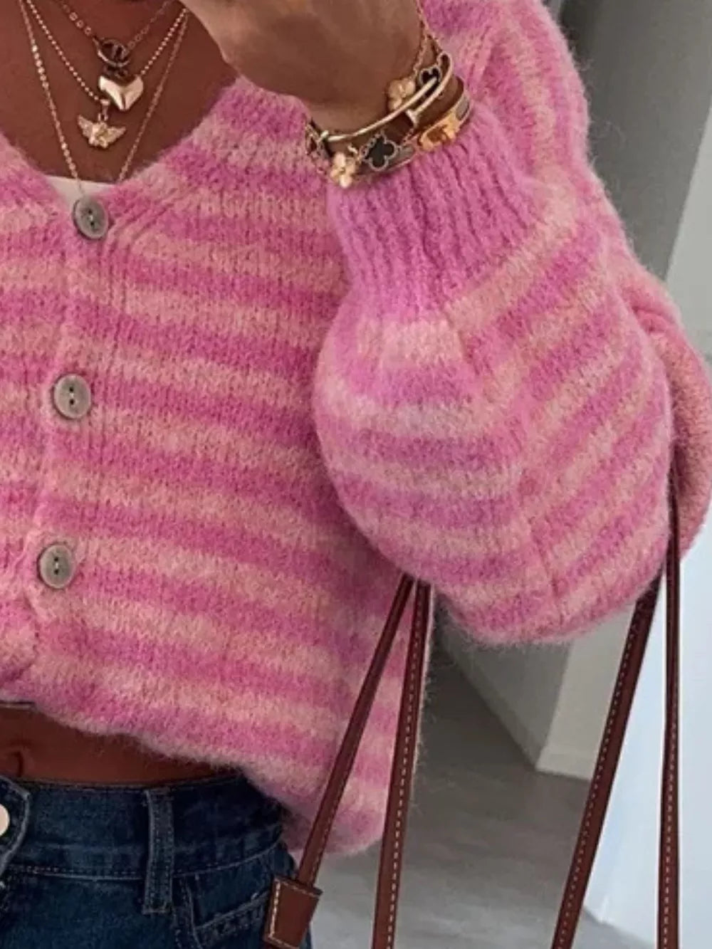 Pink striped cropped knit cardigan with balloon sleeves and button front.