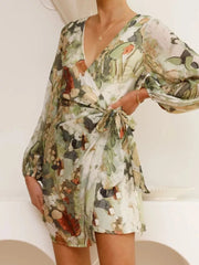 V-neck tie waist dress with abstract green and orange floral print, balloon sleeves.