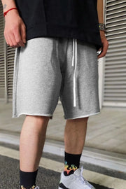 Gray relaxed fit jogger shorts with raw hem and white drawstring