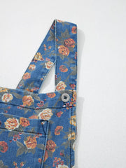 Floral denim overalls with adjustable straps and button detail.