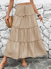 Tiered maxi skirt in tan with drawstring waist and ruffled tiers.