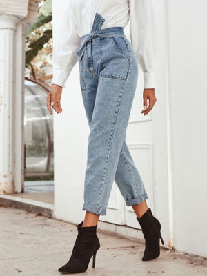 Light wash denim paperbag waist tapered trousers with tie detail and cuffed hem.