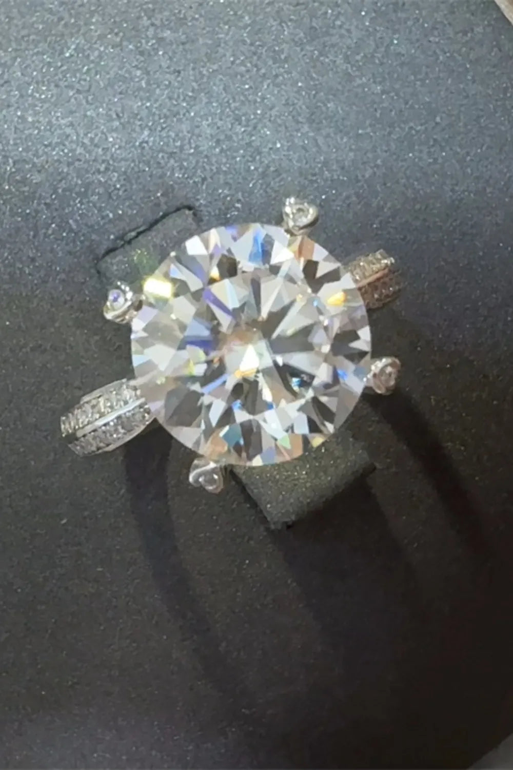 Silver pavé band round moissanite engagement ring with a large center stone.