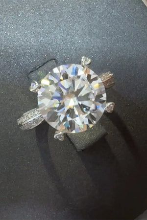 Silver pavé band round moissanite engagement ring with a large center stone.