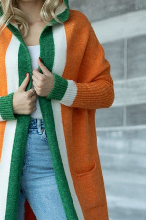 Color-blocked hooded knit maxi cardigan in orange, white, and green acrylic with pockets.